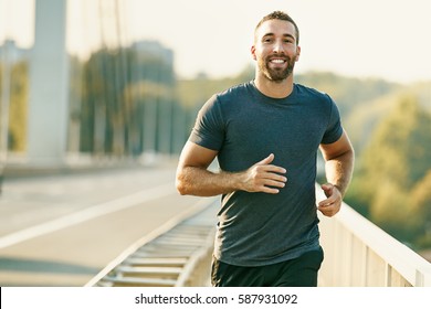 Handsome Young Man Running Across The Bridge. 