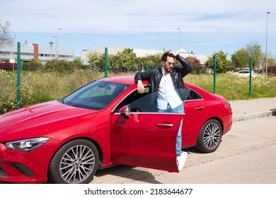 Handsome Young Man, Sculpted Body Next To His Red Sports Car. The Man Is Wealthy And Dressed In Modern Clothes. Sports Car