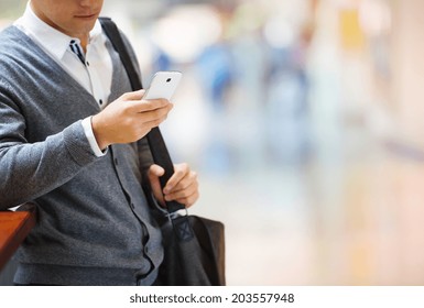 Handsome Young Man In Shopping Mall Using Mobile Phone