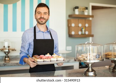 Handsome Young Man Showing A Tray Of Cupcakes From His Own Cake Shop