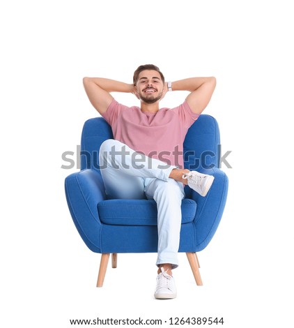 Handsome young man sitting in armchair on white background