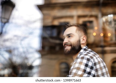 Handsome young man sitting in cafe, view from outdoors through window