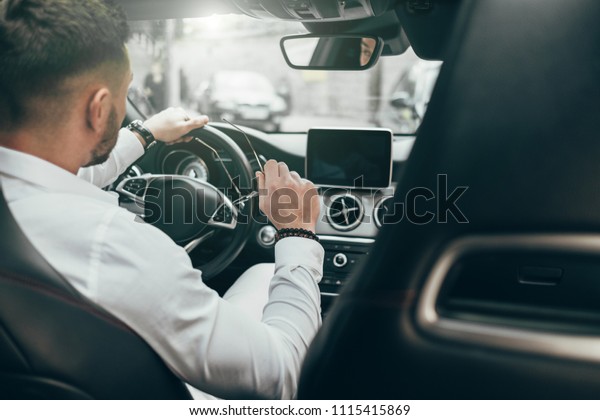 Handsome Young\
Man Sitting in the Luxury\
Vehicle