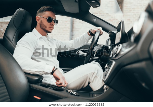 Handsome Young\
Man Sitting in the Luxury\
Vehicle