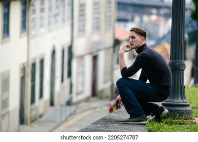 Handsome Young Man Sitting On The Street In Downtown.