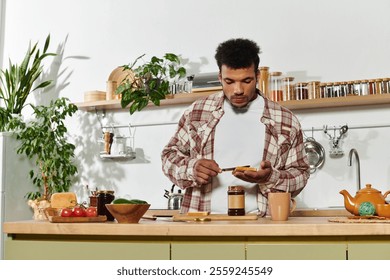 Handsome young man spreads jam on toast while enjoying a relaxing moment in his kitchen. - Powered by Shutterstock