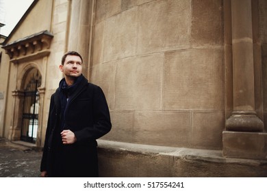 handsome and young man standing near the old cathedral - Shutterstock ID 517554241