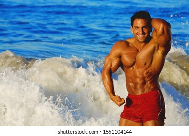 Handsome Young Man Standing On A Beach, Shirtless Wearing Boxer Shorts, Showing Muscular Fit Body