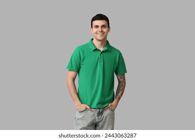 Handsome young man in stylish green t-shirt on grey background - Powered by Shutterstock