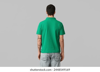 Handsome young man in stylish green t-shirt on grey background, back view - Powered by Shutterstock