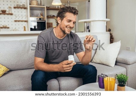 Handsome young man taking pill at home