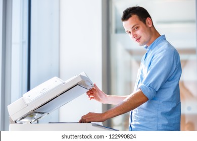 Handsome  young man using a copy machine (shallow DOF; color toned image) - Shutterstock ID 122990824