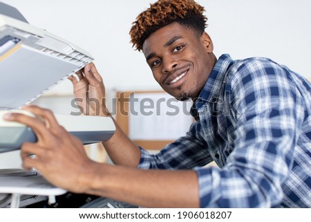 handsome young man using a copy machine