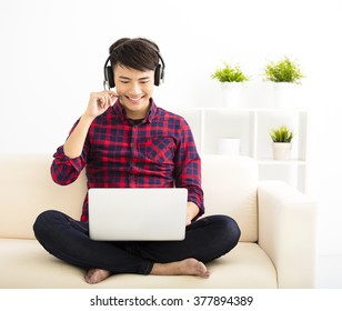 handsome young man using laptop computer with headset