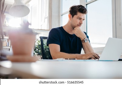 Handsome Young Man Using Laptop. Businessman Browsing Internet On His Laptop.