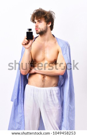 Handsome young man using perfume isolated on white background