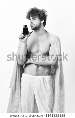 Handsome young man using perfume isolated on white background