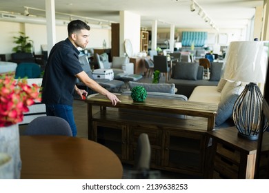 Handsome Young Man Using A Tape Measure While Buying New Furniture Table For The Living Room