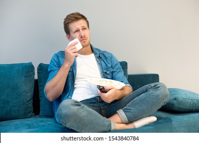 Handsome Young Man Watching Melodrama Eating Popcorn Crying On The Sofa At Home