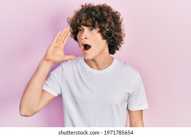 Handsome young man wearing casual white t shirt shouting and screaming loud to side with hand on mouth. communication concept.  - Powered by Shutterstock