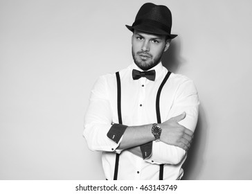 handsome young man wearing hat, suspenders, bow tie and a watch - Shutterstock ID 463143749
