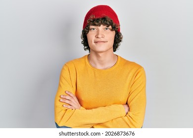 Handsome young man wearing wool hat happy face smiling with crossed arms looking at the camera. positive person. 