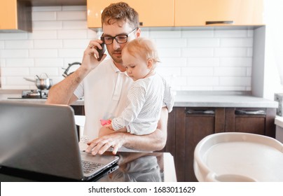 Handsome young man working at home with a laptop with a baby on his hands. Stay home concept. Home office with kids.  - Shutterstock ID 1683011629