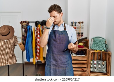 Handsome young man working as manager at retail boutique tired rubbing nose and eyes feeling fatigue and headache. stress and frustration concept. 