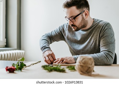 Handsome Young Man Wrapping Valentine's Day Gift.