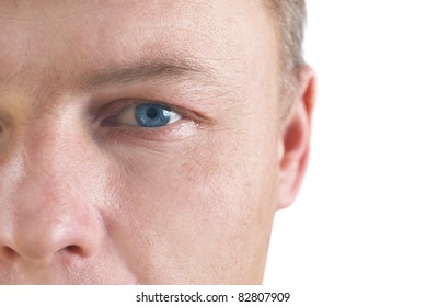 Handsome young man's face with blue eyes. Close up portrait on white background