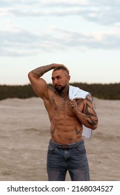 Handsome Young Muscular Italian Man Posing Shirtless On The Beach, Sunset Summer Time. Ideal Fit Body.