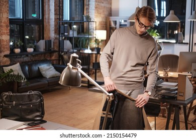 Handsome Young Office Employee Taking Jacket Off Back Seat While Leaving Office At Night