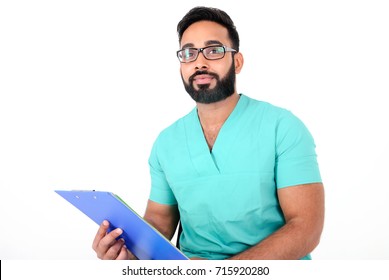 Handsome Young Paramedic (nurse) Sitting With Medical Records In His Hands And Happily Smiling, Isolated On White Background