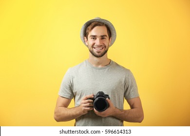 Handsome Young Photographer On Color Background