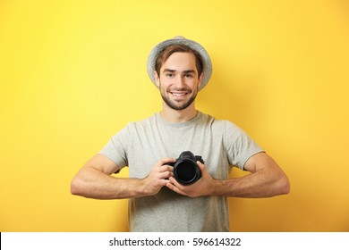 Handsome Young Photographer On Color Background