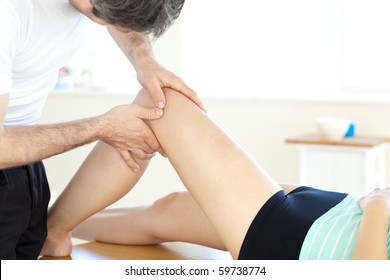 Handsome Young Physical Therapist Giving A Leg Massage In A Health Center