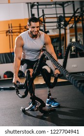 Handsome Young Sportsman With Artificial Leg Working Out With Ropes At Gym