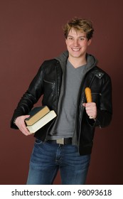 A Handsome Young Student Eating A Corn Dog In The Hallway