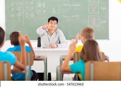 Handsome Young Teacher Teaching Chinese Language In Elementary Classroom