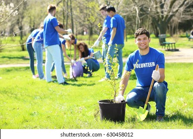 Handsome young volunteer with team outdoors - Powered by Shutterstock