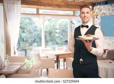 Handsome young waiter at restaurant