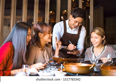 Handsome young waiter  taking an order  in hot pot reataurant - Shutterstock ID 1517783342