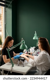 Handsome young woman manicurist doing manicure for female client. Manicure service. In professional beauty salon - Shutterstock ID 2234944417