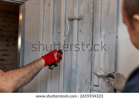 A HandsOn Painting Activity Involves Using a Roller and a Brush During a Renovation Project