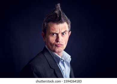 Handsone Man With Mohawk Wearing Suit In Front Of Black Background. 