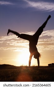 Handstand. Silhouette of a woman doing handstand at sunrise.