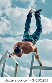 Handstand yoga pose by man on the sky background
