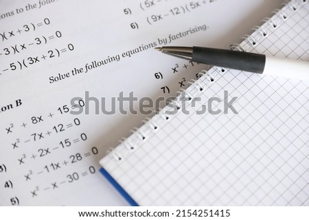 Handwriting of mathematics quadratic equation on examination, practice, quiz or test in maths class. Solving exponential equations background concept.