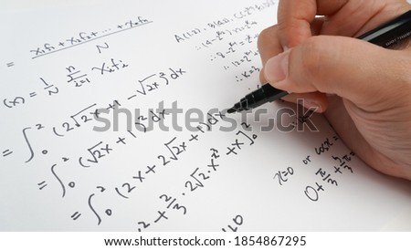 Handwriting to solve math formulas holding a computer pen. Math Formulas solves the test, practice, test or exam, background concept in math class.