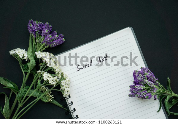 Handwriting text guest list on black background\
with violet and white small\
flowers